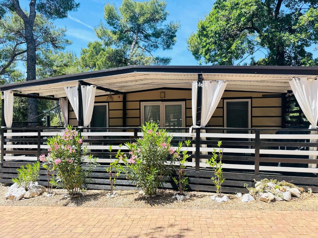 a log cabin with curtains in front of it at Mobile home SIMS in Biograd na Moru