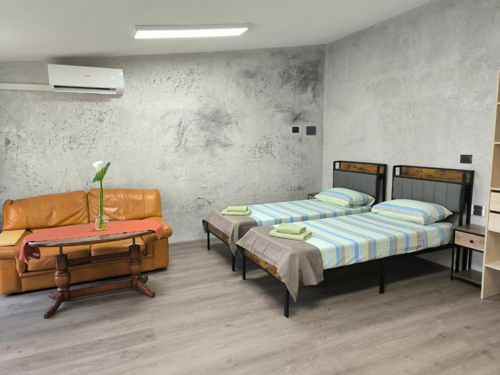 a room with two beds and a couch and a table at Villa Topaz in Capoterra