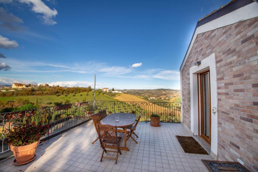 a patio with a table and chairs on a balcony at Terrazza panoramica, 3 camere e 3 bagni in Collecorvino
