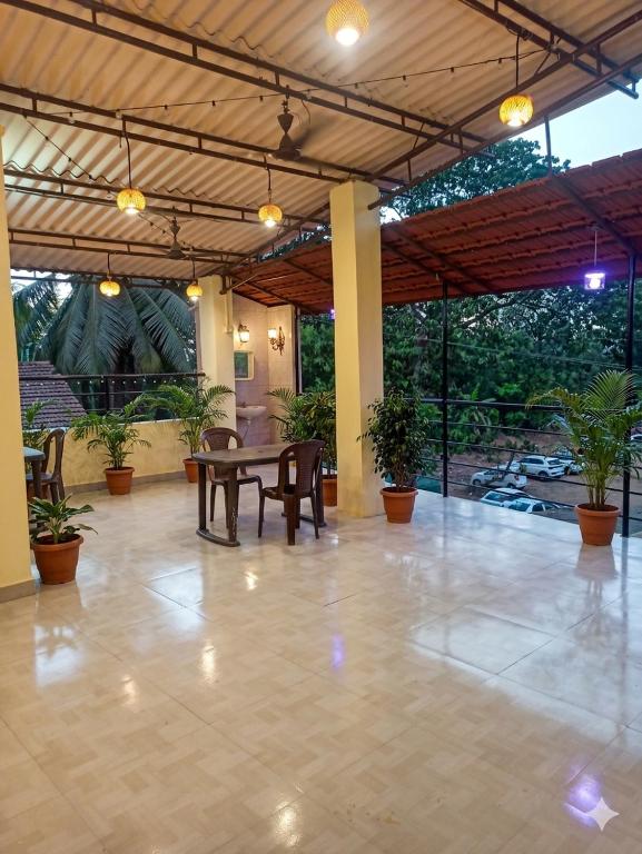 a patio with a table and chairs and plants at Caffe Bombay in Nagaon