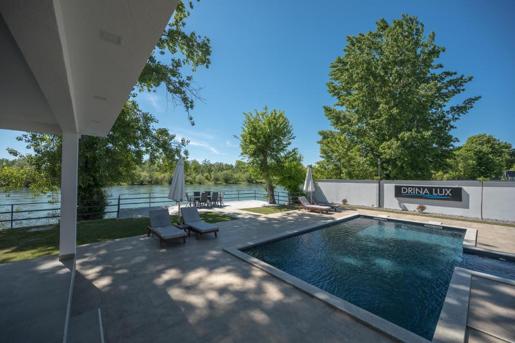 a swimming pool on a patio next to a body of water at Drina Lux in Loznica
