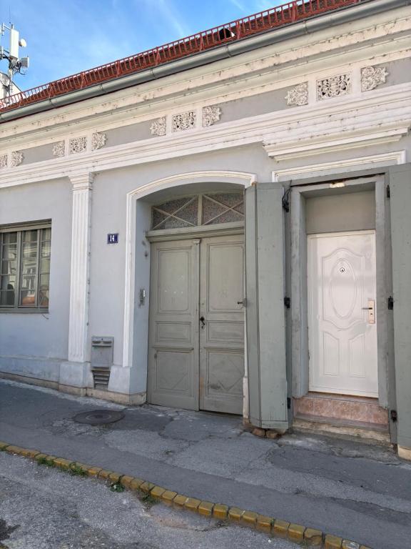 two doors on the side of a white building at Novosadska Tvrdjava Apartments in Petrovaradin