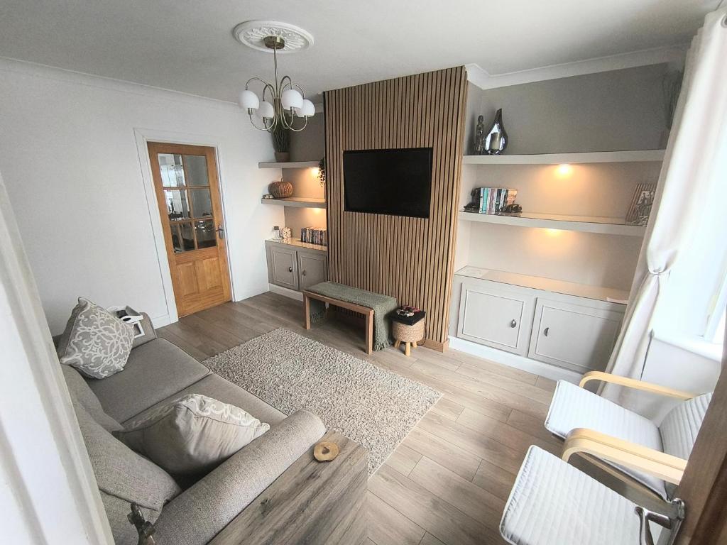 a living room with a couch and a tv at Carrick's Cosy Haven in Carrickfergus