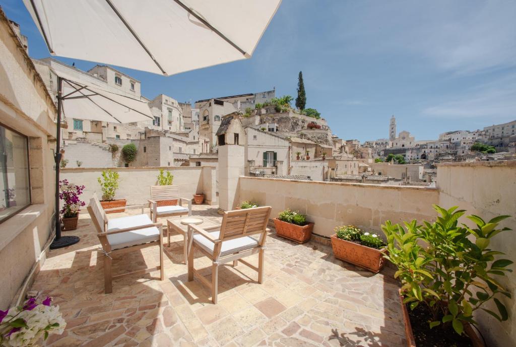 a patio with a table and chairs on a balcony at 360 view of the Sassi in Matera