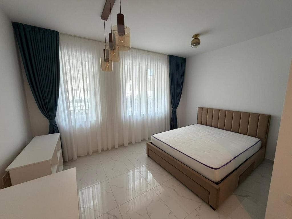 a small bedroom with a bed and curtains at Ayan Studio - Băile Felix in Sînmartin