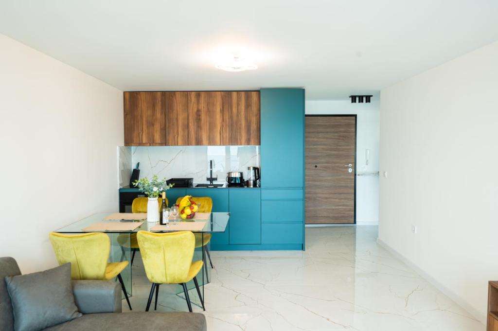 a kitchen and dining room with a table and yellow chairs at Skyline Apartments - Sea View, Pools, SPA&Free Parking in Varna City