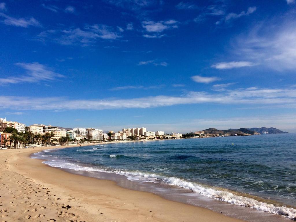 una playa con edificios y el océano en un día soleado en Beach apartment Villajoyosa, en Villajoyosa