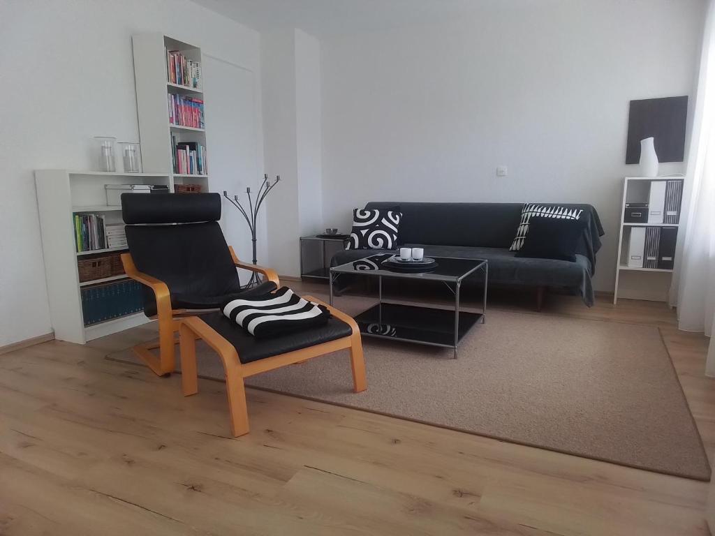 a living room with a chair and a couch at Freundliche Ferienwohnung mit großer Terasse in Aichstetten