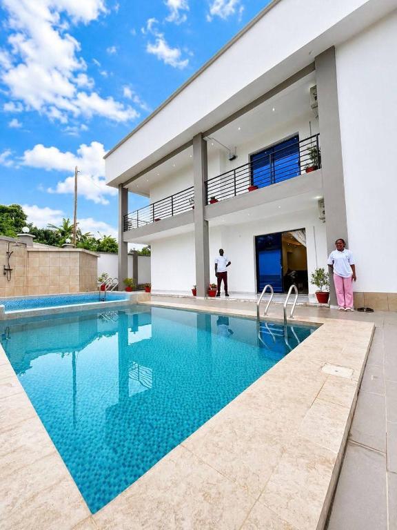 ein Haus mit Swimmingpool neben einem Gebäude in der Unterkunft Charnel hosting in Kribi