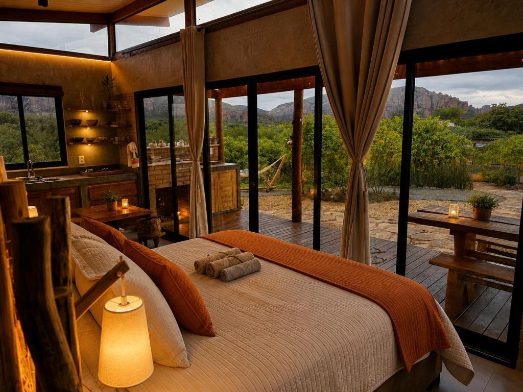a bedroom with a bed in a room with windows at Sertão do Luar in Jurubeba