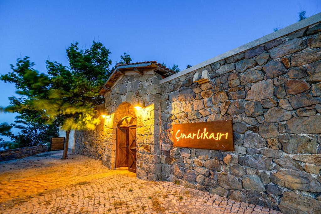 a stone building with a sign on the side of it at Cinarli Kasri in Gokceada Town