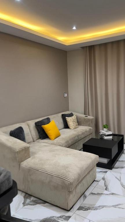 a living room with a couch with a yellow pillow at Modern 1bedroom apartment in Douala