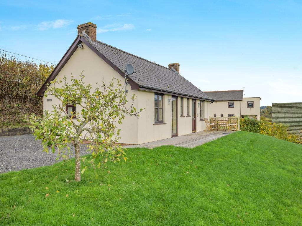 a house with a green lawn in front of it at Beacons Cottage-Uk36406 in Bronllys