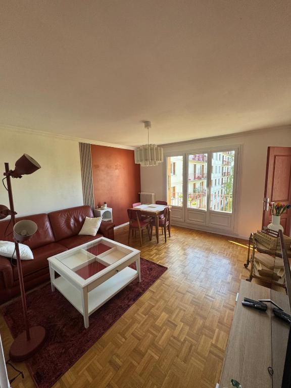 a living room with a couch and a table at Grand appartement dans une résidence à caen in Caen