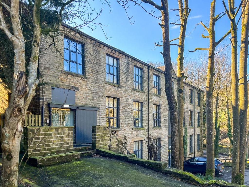a brick house with a garage and trees at Green Mill 8 - Uk51369 in Holmfirth