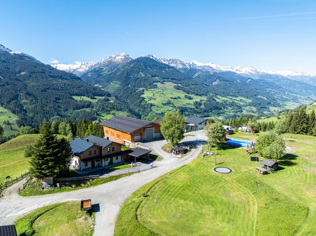 an aerial view of a home with a golf course and mountains at Bergbauernhof Familienparadies Oberhasenberghof in Taxenbach