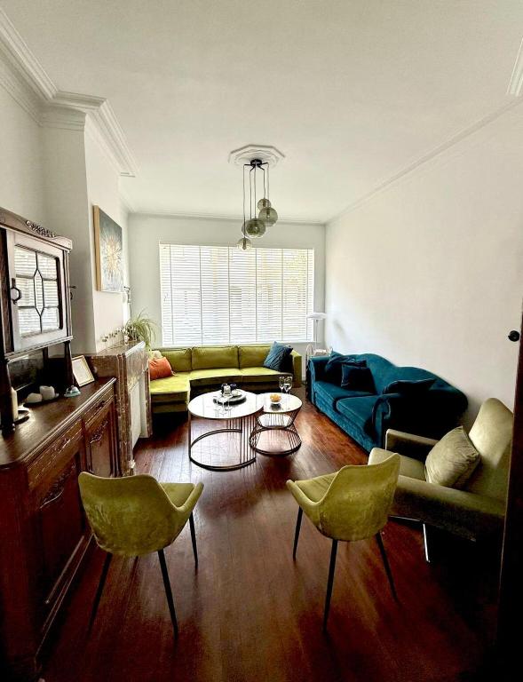 a living room with a couch and a table and chairs at Charmante Art Deco rijwoning in Ostend