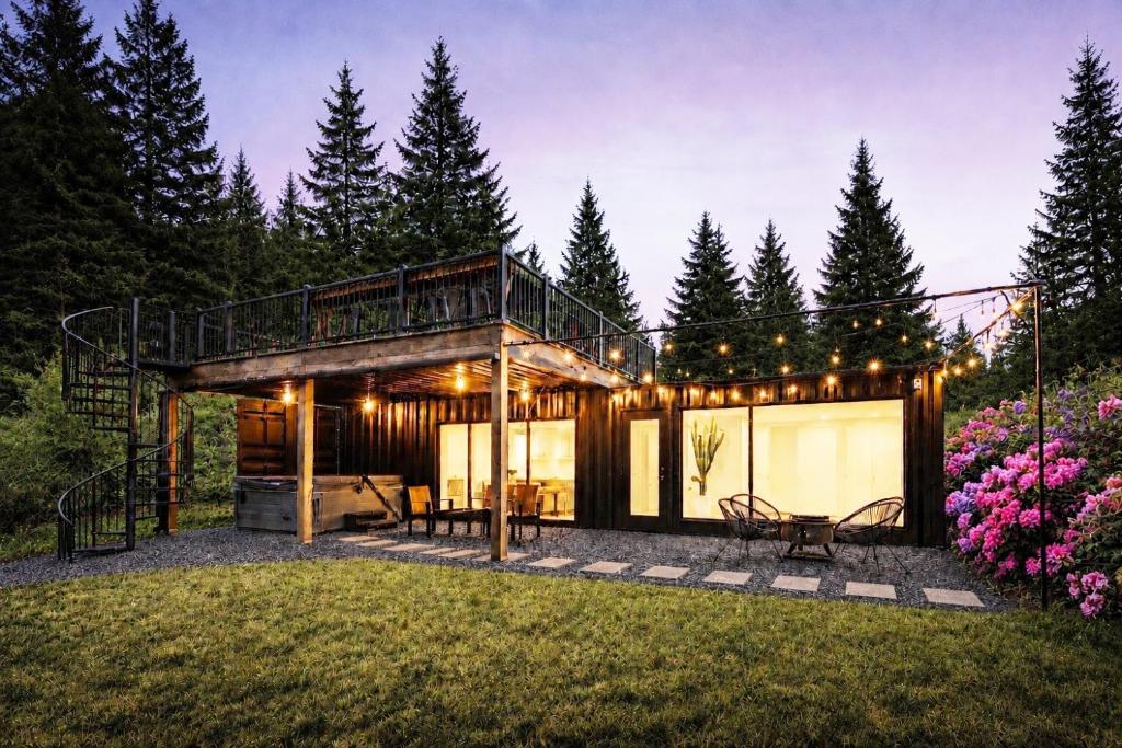 a house with a deck in the middle of a yard at Skydeck Cabin met Jacuzzi & Rooftop in Holten