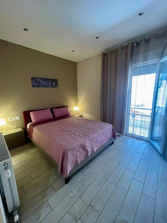 a bedroom with a large bed with pink sheets at Tsoukanas Studios in Patitiri