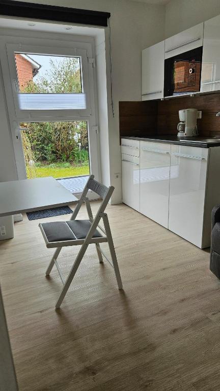 a chair sitting in a kitchen with a window at Schönes Apartment in Verl in Verl