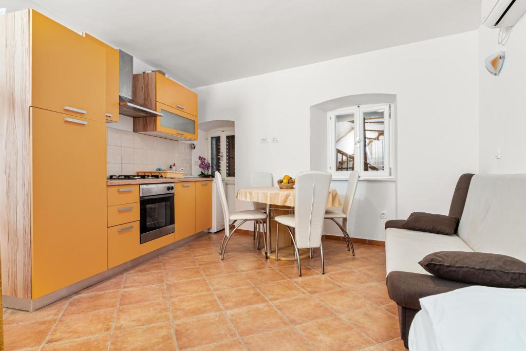 a kitchen and dining room with a table and a couch at Apartment old Town in Lovran