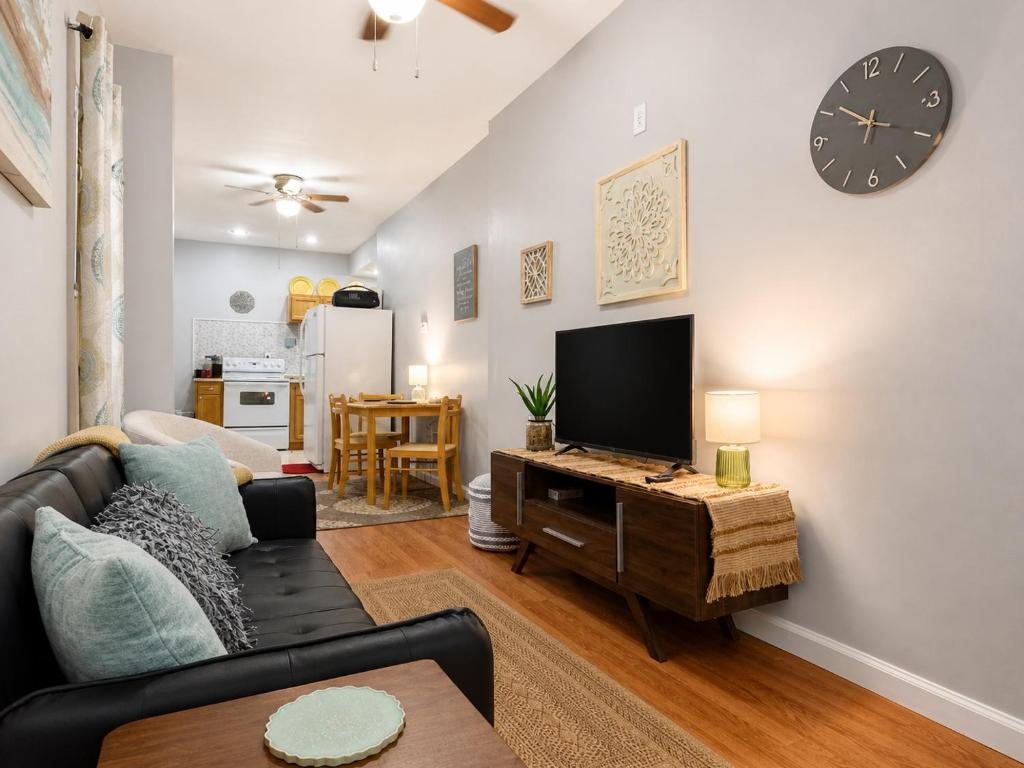 a living room with a couch and a tv at Jefferson Carriage House Hideaway in Huntington