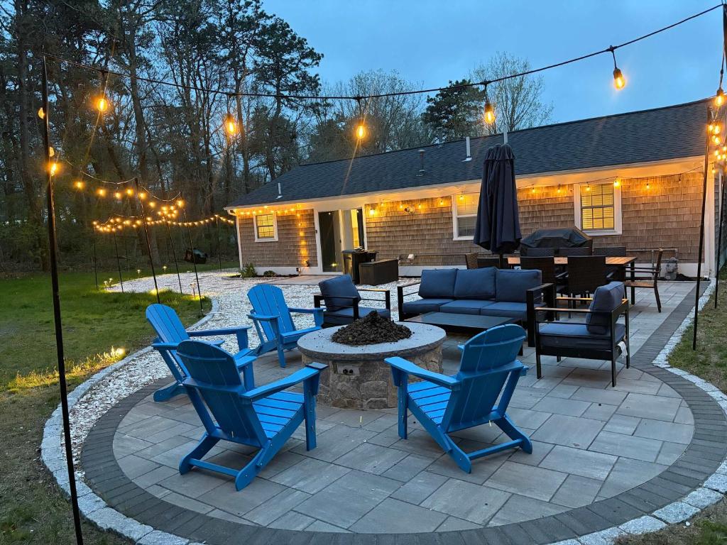 a patio with blue chairs and a fire pit at Prime Weeks Still Available, Renovated, Beaches! in Yarmouth