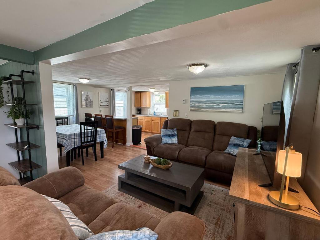 a living room with a couch and a table at Oakland Beach Cottage - Sleeps up to 4 in Warwick