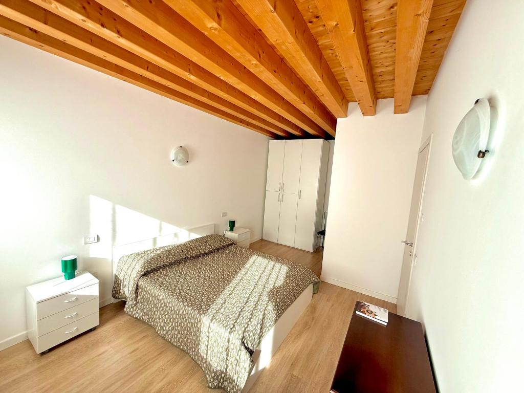 a bedroom with a bed and a wooden ceiling at Ca' Luciana Valdobbiadene in Valdobbiadene