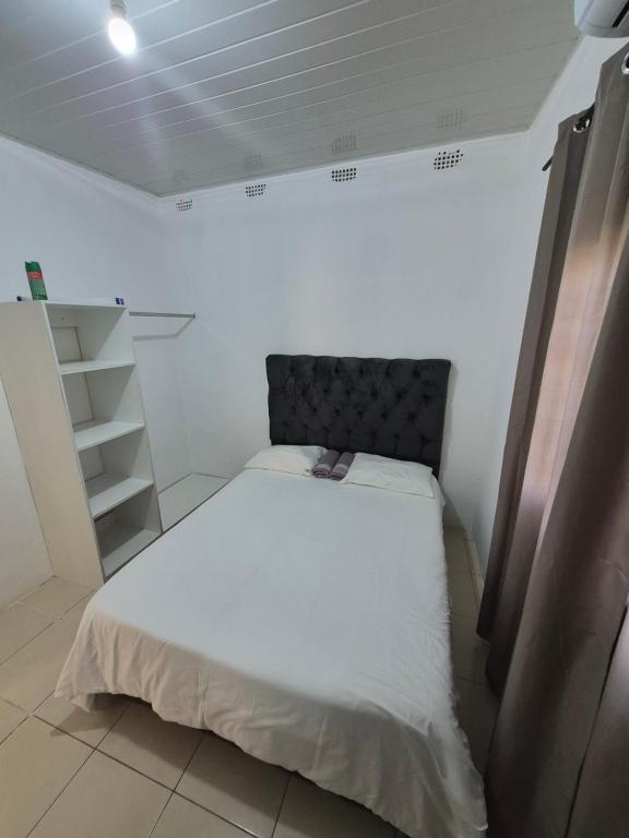 a small bedroom with a bed in a room at Avery's Cottage in Livingstone