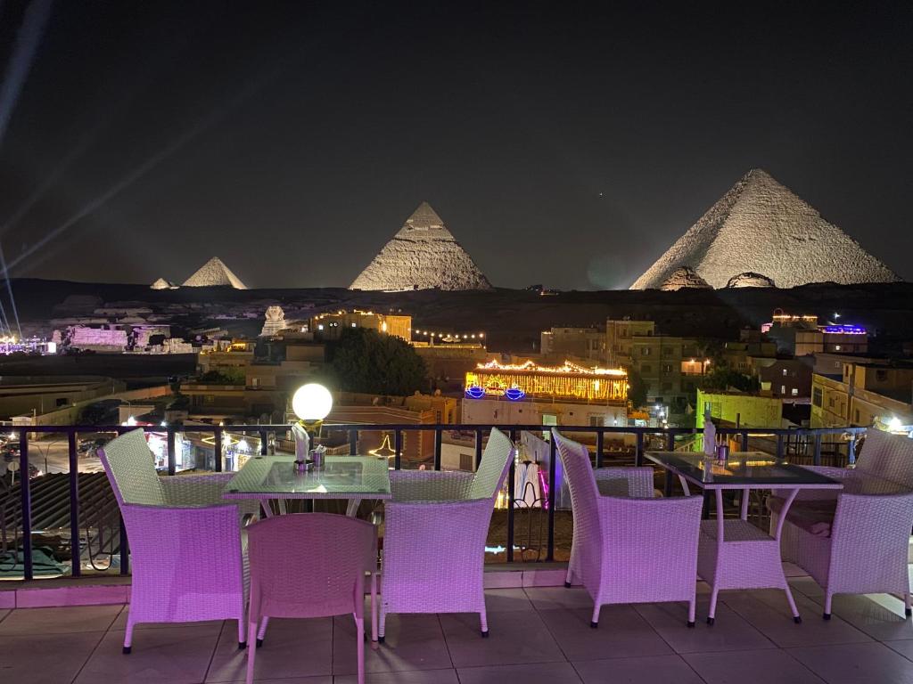 a view of the pyramids from a restaurant with purple chairs at Golden Pyramids Inn in Cairo