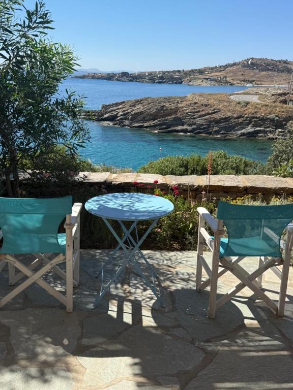 a table and two chairs and a table with a view of the water at Villa Aphrodite in Koundouros