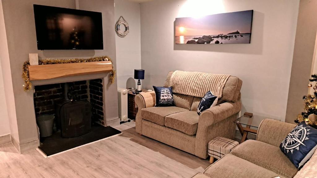 a living room with a couch and a fireplace at Beach 100m - Sea View - Log Burner - Dogs Welcome in Bridlington