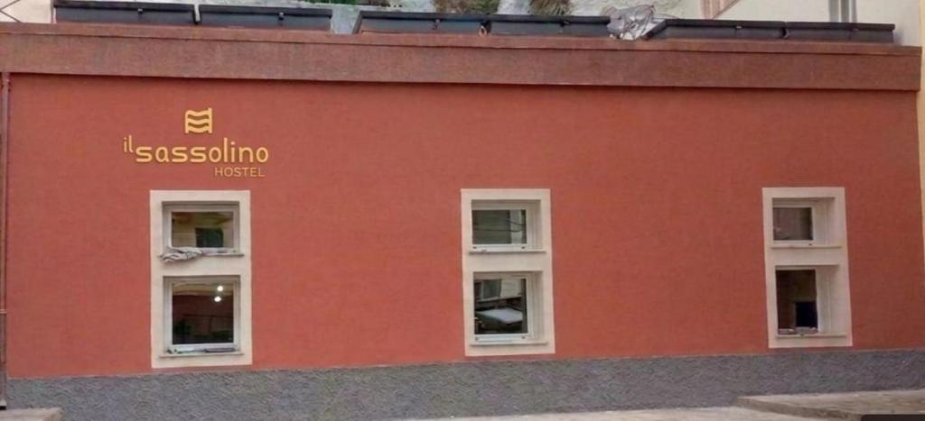 a red building with three windows on the side at Il Sassolino in Riomaggiore