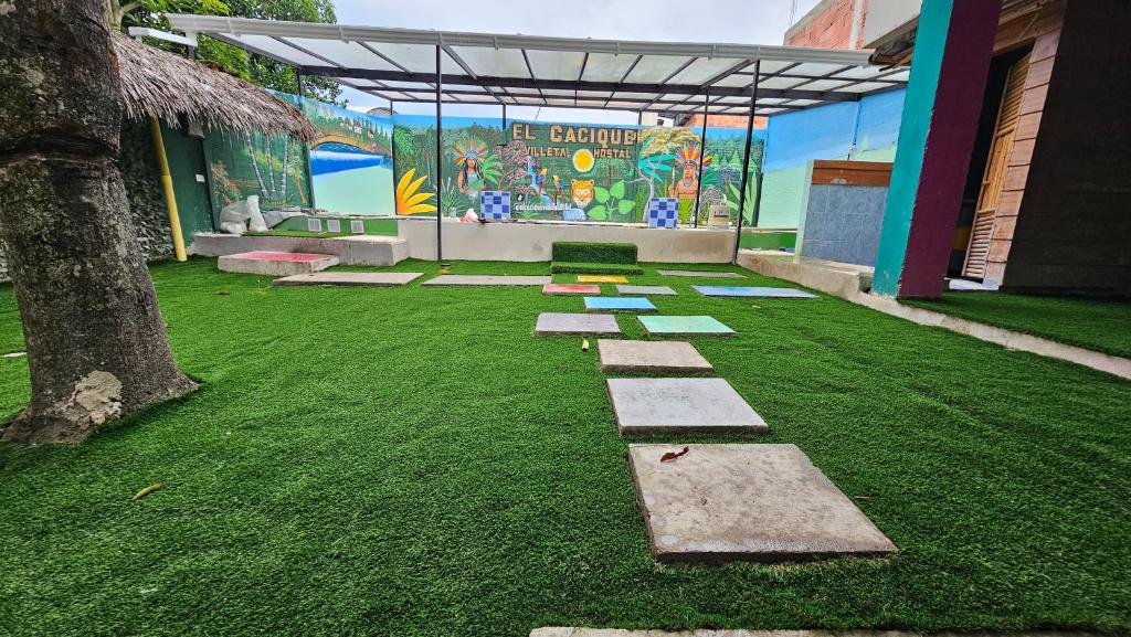 a garden with stepping stones in front of a building at El Cacique Villeta Hostal in Villeta