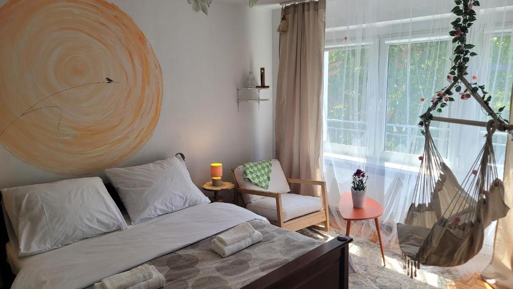 a bedroom with a bed and a chair and a window at Happy One Park Apartment in Świdnica