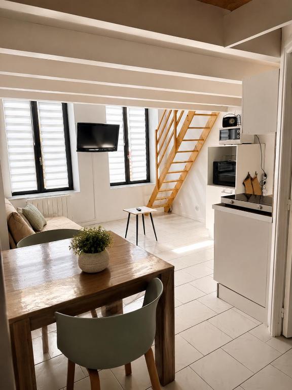 a kitchen and living room with a wooden table and chairs at studio les volets bleus in Boulogne-sur-Mer