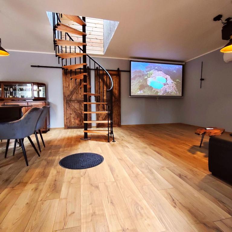 a living room with a staircase and a flat screen tv at LoftLove Lubianka in Starachowice
