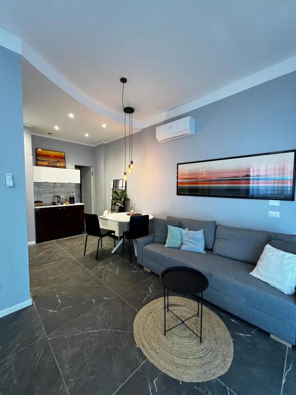 a living room with a blue couch and a table at Suite excelsior garden living in Parma