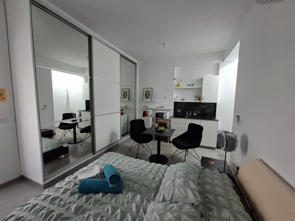 ein Schlafzimmer mit Bett, Schreibtisch und Stühlen in der Unterkunft Cozy studio! in Paphos City