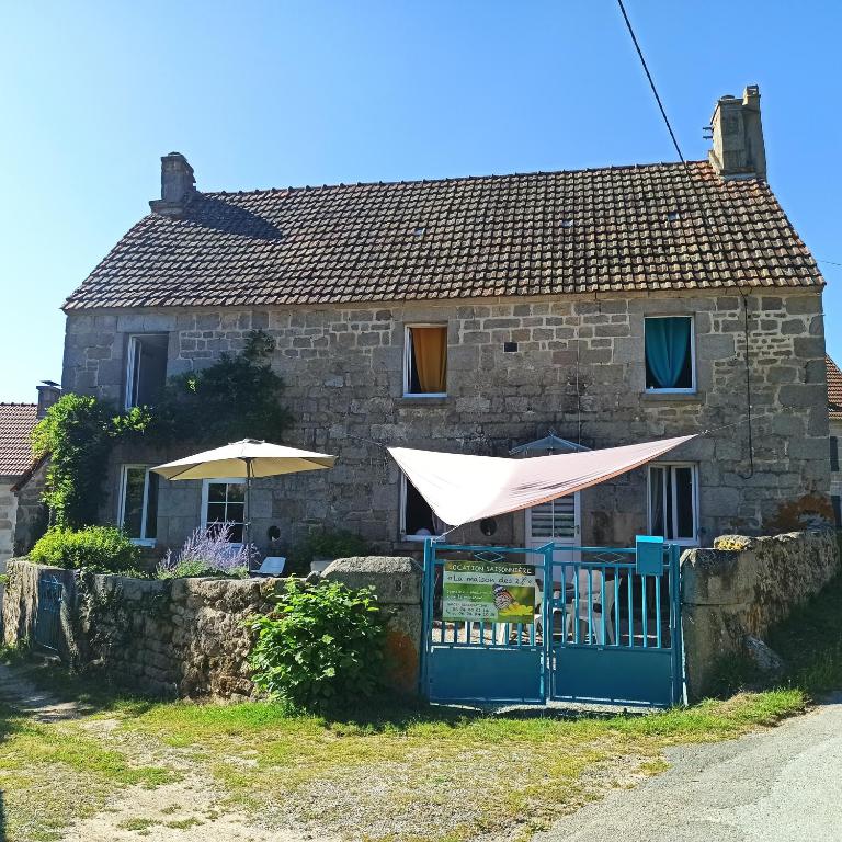 a house with a blue gate and an umbrella at La Maison des 2L in Saint-Médard
