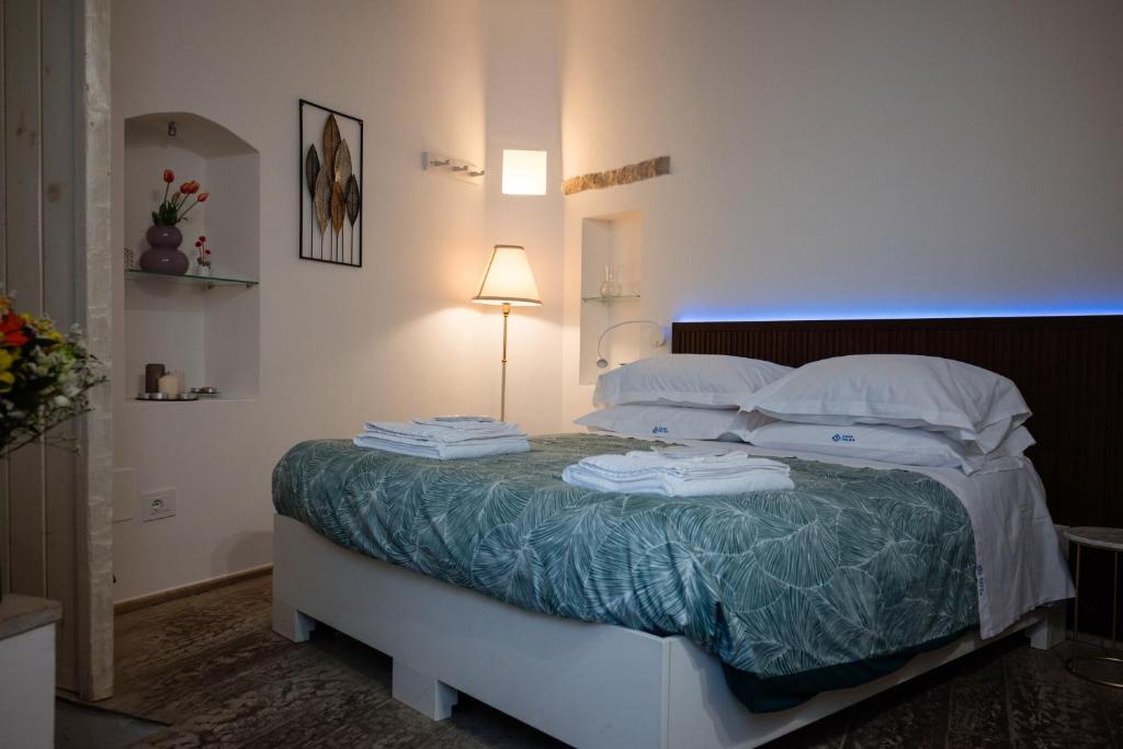 ein Schlafzimmer mit einem Bett mit weißen Laken und Kissen in der Unterkunft Casa Felda in Altamura