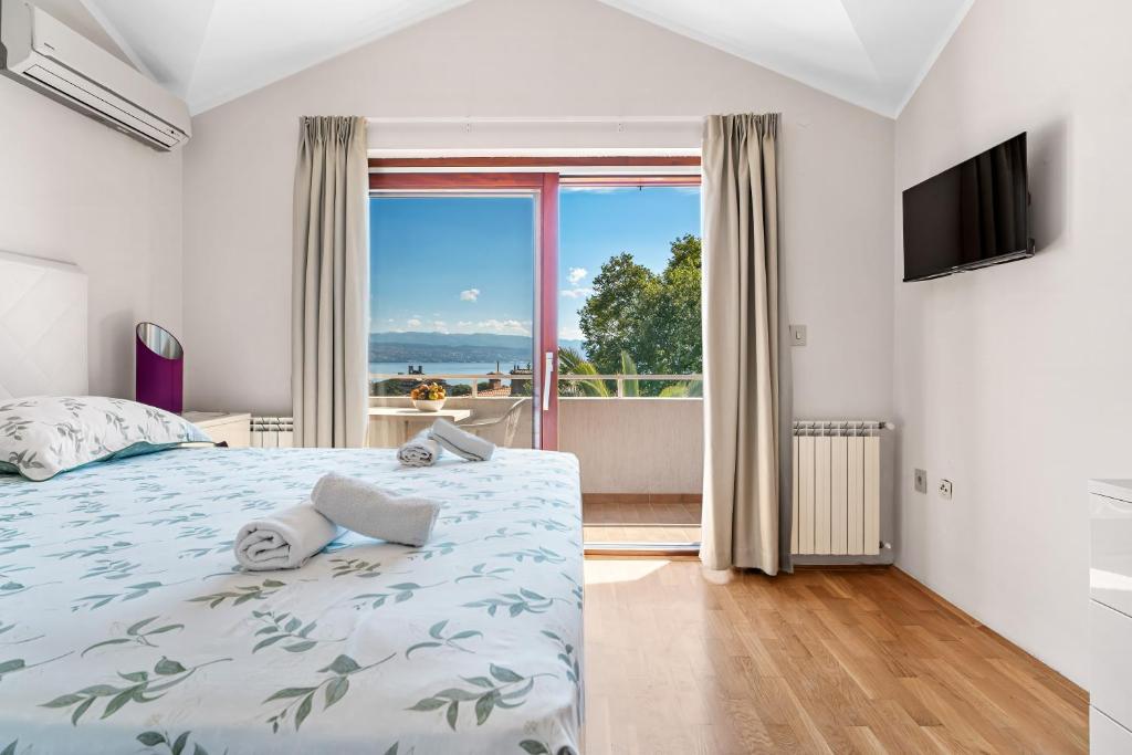 a bedroom with a bed and a large window at Villa Lili in Lovran