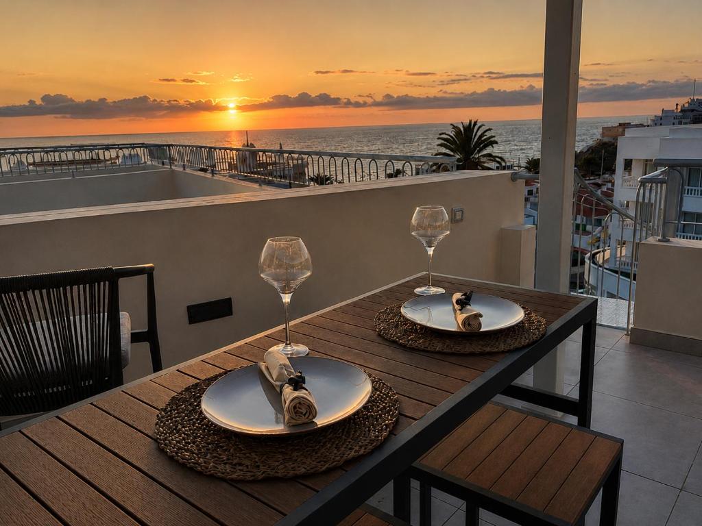 a table with two wine glasses and a view of the ocean at Ocean View in Puerto de Santiago
