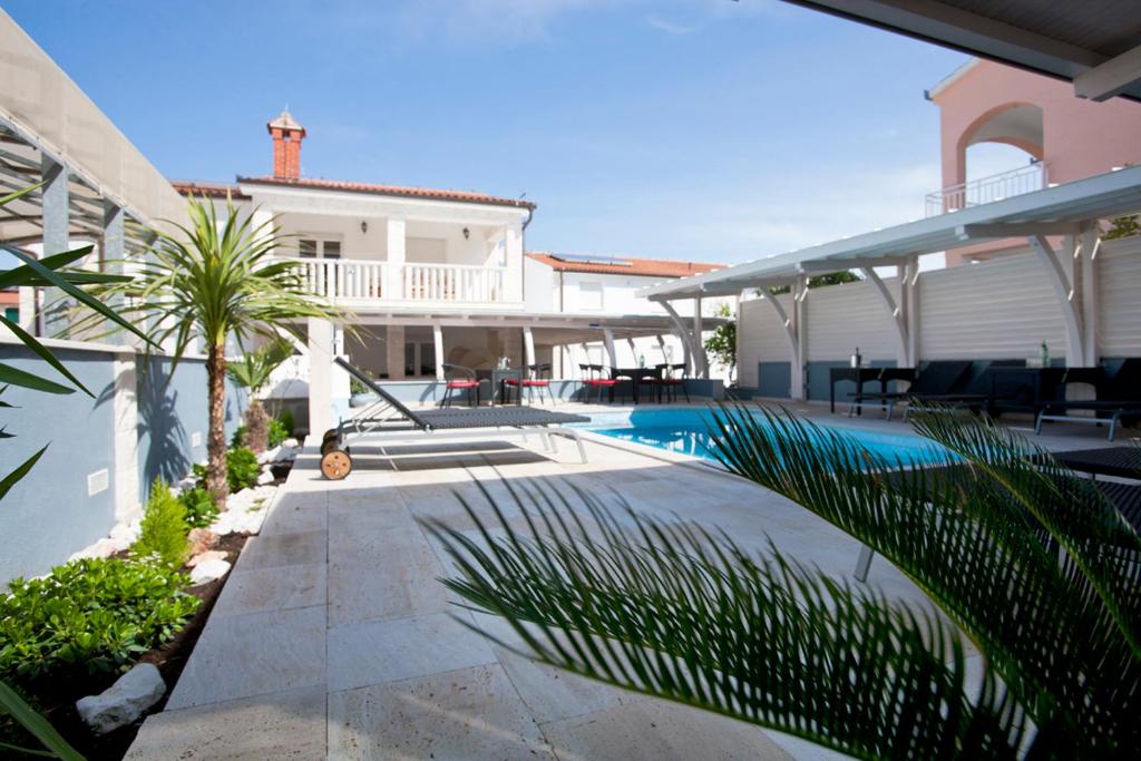 un patio trasero con piscina y una casa en Villa Kruna Grada, en Trogir