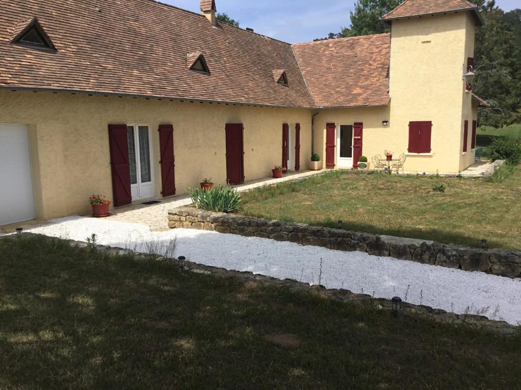 a house with red doors and a yard at La maison du bonheur in Milhac