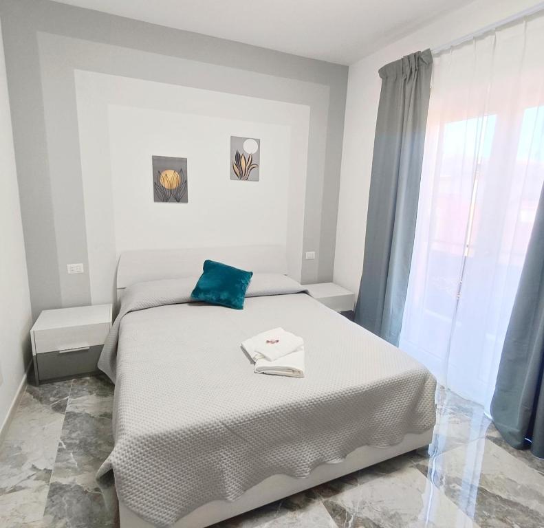 a white bedroom with a bed and a window at Dolce Luna in Isola Sacra