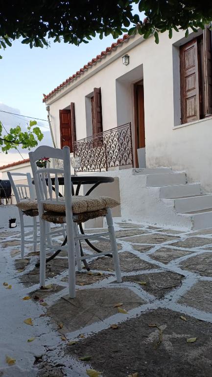 a bench and a table in front of a building at George's house samos in Pagóndas