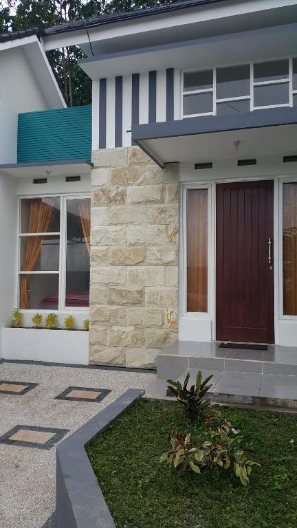 a house with a red door and a yard at Ken's Villa 8 in Batu