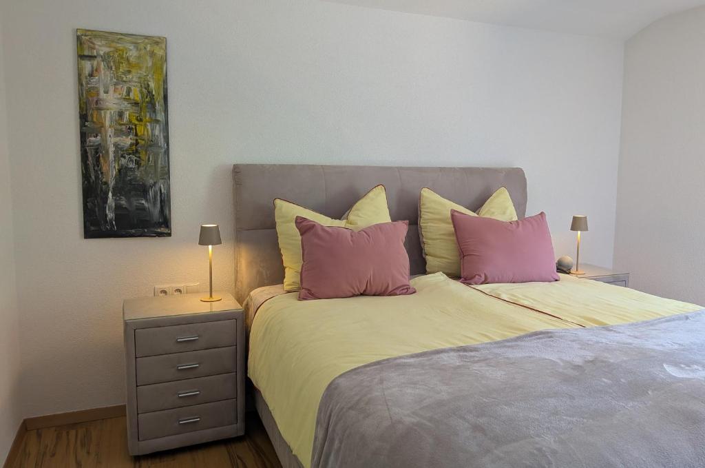 a bedroom with a bed with pink pillows and a nightstand at Mitzi's Zauberblick in Landeck